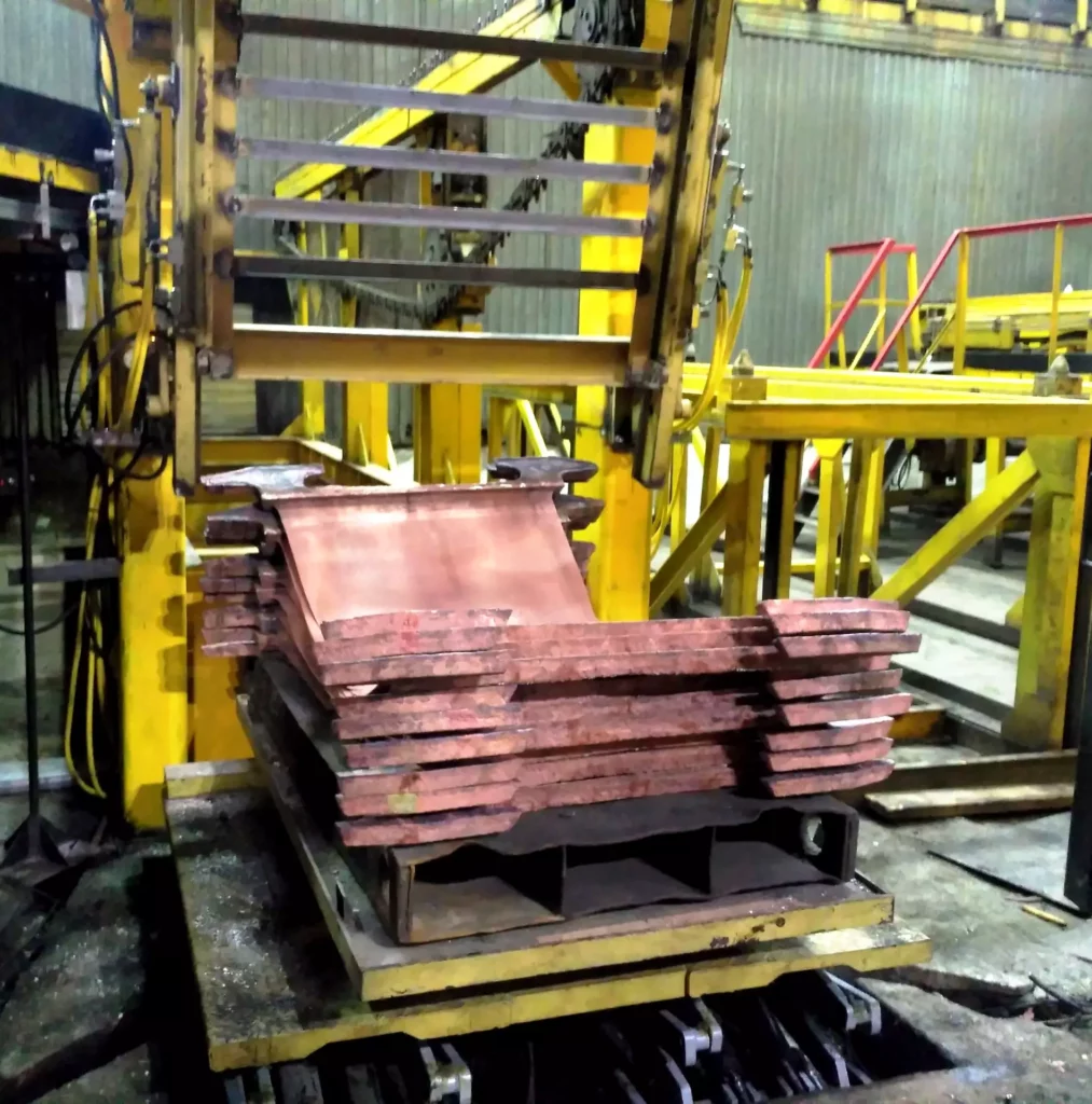 Automatic discharger/stacker for copper slabs from the scrap conveyor of a copper electrolysis line
