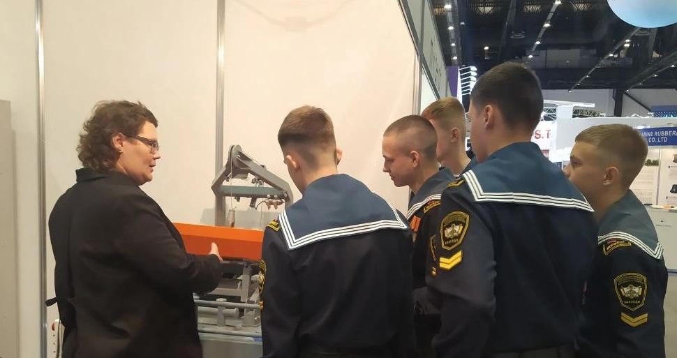 Главный инженер ООО "Ижорские Гидросистемы" Татьяна Нестерова рассказывает курсантам о спуско-подъемном устройстве на стенде выставки НЕВА-2023